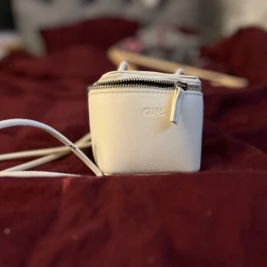 Liten C.W väska  - En vit/beige väska kub väska från Åhléns ( C.W ).  * det finns lite märken av något på baksidan. Dem var där när jag köpte den *