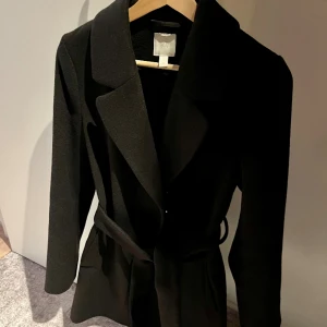 Kappa med pälskrage  - Svart kort kappa med avtagbar pälskrage. Från H&M. Knappt använd! Storlek 34, ganska stor i storleken.