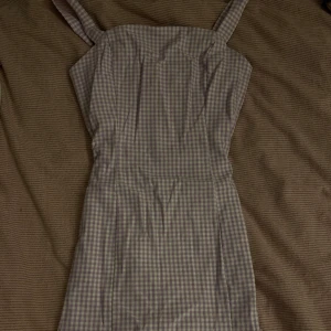 Rutig sommarklänning! - Lila/vit rutig sommarklänning! den är stretchig, åtsittande och mycket bekväm. Pytteliten slits!