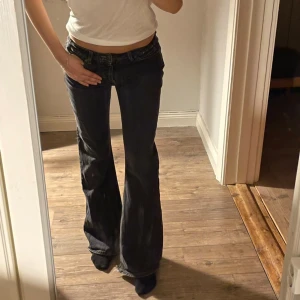 Lågmidjade bootcut jeans - Ett par ursnygga bootcut jeans från Vila! Dessa är också lågmidjade. Färgen på dessa är grå/svart Innerbenslängd: 80cm 