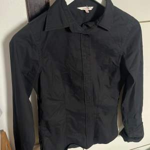 En snygg svart skjorta som ger en fin passform på kroppen