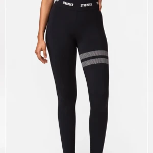 Stronger tränings byxor  - Ett par träningsbyxor från stronger i färgen grön/beige. Knappt använda och är i ett mycket bra skick. Perfekt att ha nu till våren/sommaren. Ny pris 699. 