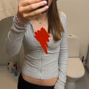 Grå ribbad kofta/topp från BikBok - Säljer en ljusgrå ribbad kofta från BikBok i storlek S. har dragkedja framtill, huva och långa ärmar. Den sitter tight och är väldigt stretchigt material. Väldigt mjuk i tyget🥰