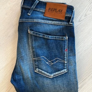 Replay Anbass jeans - Snygga Replay Anbass jeans i mörkblå tvätt med slitningar och kontrastsömmar. Slim fit i strechig bommulsdenim. Storlek 31/32 och måtten på jeansen hittar du på bild 4. Skriv gärna vid andra funderingar😇
