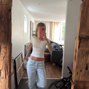 Vit  offshoulder topp - Säljer en vit croppad topp med offshoulder-design och korta ärmar. Toppens material är mjukt och stretchigt, troligtvis bomull eller en bomullsblandning. Sitter tight och har en enkel, stilren look som är lätt att matcha.