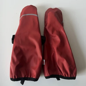 Röda vattentäta vantar från PAX - Säljer ett par röda vattentäta tumvantar från PAX med svart kant och reflexdetalj. Insidan är fodrad med mjuk beige fleece för extra värme. Står tyvärr inte storlek, totallängd ca 27-28cm.