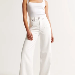 Vita wide jeans med hög midja - Snygga vita jeans med hög midja och breda ben. Klassisk femficksmodell med raka sömmar och stilren look. Perfekta för dig som gillar en trendig och avslappnad stil.