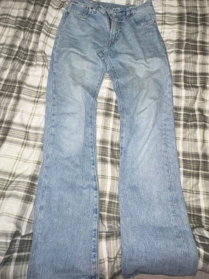 Levi's 551 ljusblå jeans bootcut - Säljer ett par Levi's 551 jeans i ljusblå tvätt med klassisk bootcut-passform. Jeansen har fem fickor, knapp och dragkedja fram samt Levi's läderpatch bak. Materialet är slitstark bomull och jeansen har en normal passning.