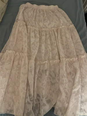 Lång vit kjol - En vit kjol med blommönster på i storlek S/M. Använd men inga skador i den vad jag har märkt 