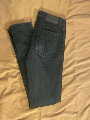 Mörkgrå jeans från Tiger of Sweden - Snygga mörkgrå jeans från Tiger of Sweden i mycket bra skick och inga defekter🔥 Jeansen är i slimfit och är stretchiga i materialet och är W30/L32!👌Bara att höra av dig om du har andra funderingar👑Bälte ingår ej.