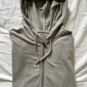 Beige hoodie från Polo Ralph Lauren - Säljer en mer eller mindre oanvänd beige hoodie från Ralph Lauren. En mycket skön tröja, som har lite stretchigt material. Armarna är långa ärmar och den har ribbade muddar vid ärmsluten. Priset kan eventuellt diskuteras. 