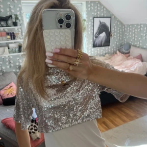 Glittrig croppad topp i silver - Säljer en superglittrig croppad topp i silver med paljetter över hela ytan. perfekt för att sticka ut. Storlek xs❣️❣️