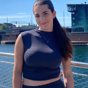 Blå topp från Gina Tricot - Säljer en blå  topp från Gina Tricot. Toppen är ärmlös med hög hals och har snygga rynkade detaljer i sidorna. 