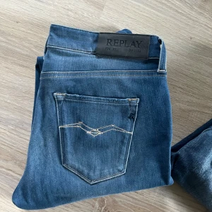 Blå jeans från Replay - Snygga blå jeans från Replay med klassisk femficksdesign och coola kontrastsömmar på bakfickan. Jeansen har en stilren tvätt och är perfekta för dig som gillar en avslappnad men trendig look.