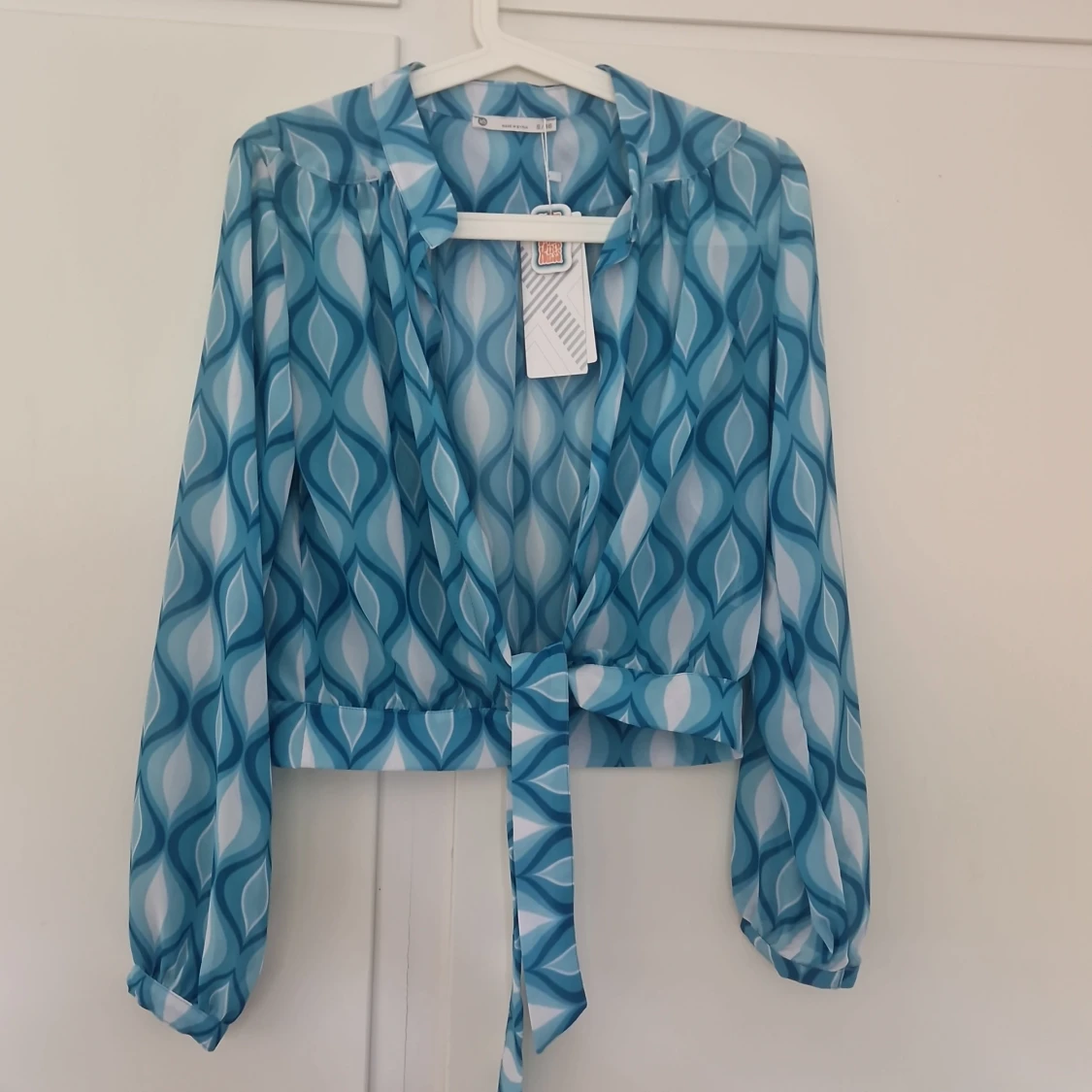 Blå mönstrad omlottblus med knyt