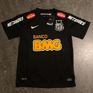 Svart Neymar Jr Santos FC tröja - Ny svart Nike Santos 2012-2013 Neymar Jr tröja, med prislapp. Storlek S, passar även som M. Mått i bild 4.