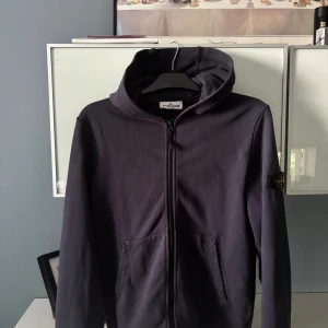 Stone island zip hoodie - Säljer en mörkblå stone island zip hoodie då den inte kommer till användning längre. Passar mig bra på 175cm! Finns inga hål eller slitningar. Vid frågor är de bara att höra av sig!