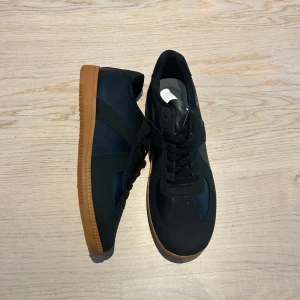 Svarta sneakers med brun sula - Skorna är helt nya och har aldrig använts. Köpta direkt från Arveilos webbutik. Storlek 43, men de är mer som en 41-42. Vita snören ingår.  Om du har mer frågor om skorna, skicka ett meddelande!