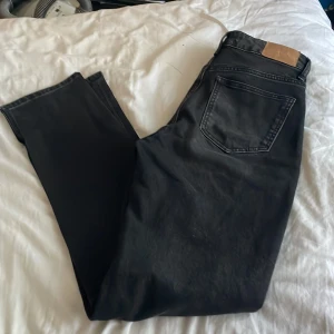 Svarta jeans från Zara, storlek 38 - Svarta jeans från Zara i klassisk femficksmodell med snygga kopparfärgade nitar. Jeansen har raka ben och normal passform, tillverkade i ett slitstarkt bomullstyg. Perfekta för dig som gillar en stilren och enkel look.