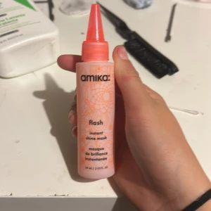 Amika Flash Instant Shine Mask 60ml - Amika Flash Instant Shine Mask i en snygg ljusrosa och orange tub på 60 ml. Masken är framtagen för att ge håret extra glans och har en smidig applikator. Perfekt för dig som vill boosta hårets lyster snabbt. Snygg design med blommönster och tydlig logga.