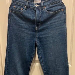 Blå jeans från Perfect Jeans, GinaTricot - Klassiska blå jeans från Perfect Jeans i rak modell med fem fickor och snygga kontrastsömmar. Byxorna har normalhög midja, dragkedja och knapp framtill samt bälteshällor. Perfekta för en stilren och enkel look.