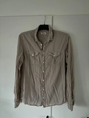 Zadig Voltaire skor - Snygg ljus beige urläcker Zadig Voltaire skjorta med dubbla bröstfickor och storlek S. Använt men bra skick, bara att stryka den så blir den som ny! Tveka inte vid minsta fråga eller fundering!
