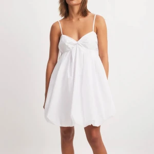 Vit kort klänning från NAKD - Säljer denna vita klänningen från NAKD. Helt oanvänd med lapparna kvar. Perfekt till studenten!🙌🏽