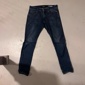 Replay Anbass slim fit jeans blå - Mörkblå slim fit jeans från Replay, modell Anbass. Klassisk femficksdesign med dragkedja.  Hör av dig vid funderingar!!