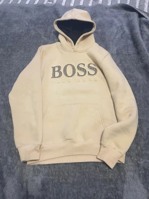 Säljer en beige Hugo Boss hoodie - Säljer en Hugo Boss hoodie bästa kvalitet skön och bra.