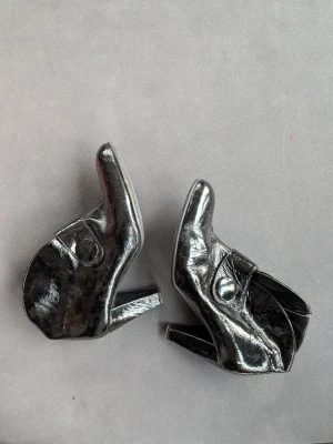 Svarta italienska stövletter y2k - Säljer ett par svarta stövletter i äkta skinn, tillverkade i Italien. Skorna har en markerad klack, rund tå och en bred rem med knappdetalj över vristen. Perfekta för dig som vill ha en edgy och stilren look.