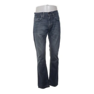 Levi's 511  - Snygga Levi's 511 jeans i mörkblå tvätt med klassisk femficksdesign och knappgylf. Storlek 31/30. Jeansen har en slim passform. Perfekta för dig som gillar en modern och stilren look.