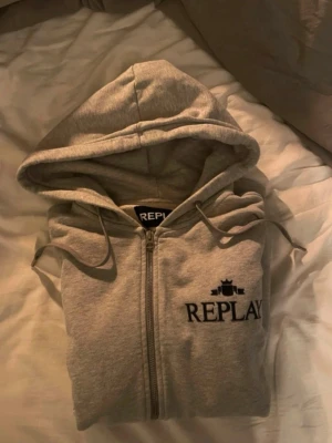 Replay tröja med dragkedja  - En grå replay Hoddie med dragkedja riktigt bra passform, bekväm och snygg ny pris på denna tröjan är 1299kr. Och använd 2-3 gånger så alltså mycket bra skick utan defekter 