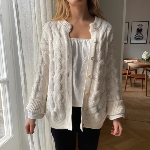Vit kabelstickad kofta med knappar - Slutsåld och eftertraktad  kabelstickad kofta. Koftan är använd ett fåtal gånger och därmed i ett mycket fint skick.                                                           Skriv för frågor💕