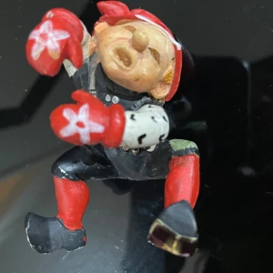 Candy Designs Norway Boxer Figurine - Unik handmålad boxerfigur från Candy Designs Norway. Färgglad och charmig med röda handskar och mössa. Viss färgslitage syns på stövlar och ben, men i gott skick för sin ålder. Perfekt för samlare eller som dekoration.