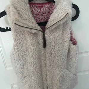 Beige fluffig pälsväst  - Supermysig beige pälsväst. Skulle säga storleken är mellan xs-s. 