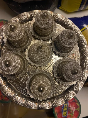 Lyxigt turkiskt kaffekoppsset med bricka - Exklusivt turkiskt kaffekoppsset med 6 koppar, lock och fat, dekorerade med glittrande stenar och vackra orientaliska mönster. Brickan är elegant graverad. Setet är i mycket gott skick, perfekt för festliga tillfällen eller som present.