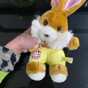 MAGTOYS Swedberg AB Mjukisdjur Kanin - Söt mjukisdjur -kanin från MAGTOYS Swedberg AB, ca 30 cm lång. Kaninen har mjuk päls, stora ögon och är klädd i gula byxor med rosa-rutiga detaljer. Skicket är mycket gott, inga synliga defekter eller slitage. Perfekt som present eller samlarobjekt.