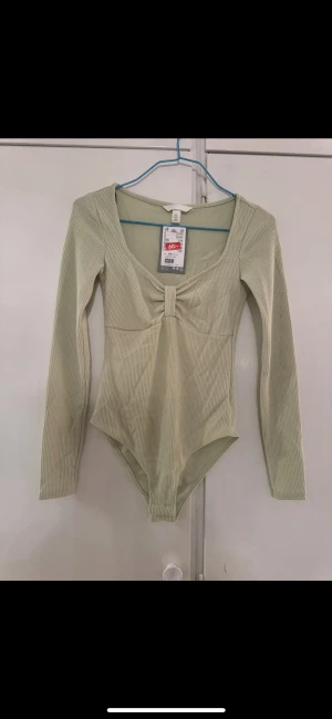 topp / body h&m - En oanvänd body från hm passar xs/s. oanvänd. 