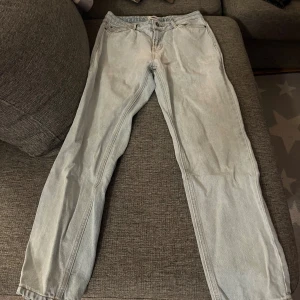 Ljusblå jeans från Grunt, storlek 28 - Säljer ett par ljusblå jeans från Grunt i storlek 28. Modellen har klassisk femficksdesign, raka ben och är tillverkad i ekologisk bomull. Jeansen har normal passform och är perfekta för dig som gillar en enkel och clean look.