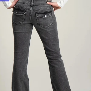 Lågmidjade grå jeans  - Snygga  jeans från Gina Tricot Young i storlek 152. Jeansen har två knappar i midjan, fickor med knapp bak och passformen är bootcut. Nypris 349kr mitt pris 99kr pågrund av lite slitning vid benen, annars är dom i fint skick! Skriv privat för fler bilder eller om du har några frågor 