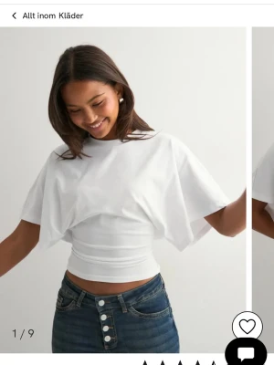 Vit croppad topp med vida ärmar - Säljer en vit croppad topp med vida, korta ärmar och tight midja. Toppen har en unik design med lösare tyg upptill och smal passform nedtill. Perfekt för dig som gillar trendiga och stilrena plagg.