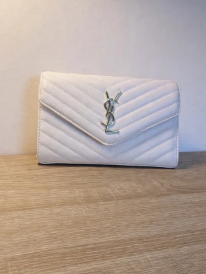 Saint Laurent CASSANDRE ENVELOPE CHAIN WALLET - De är nu dax att sälja min Saint Laurent väska. Väskan har online verifierats på tradera, jag kan även sätta dit en kedja vid köp. Lite sliten på själva lappen som stänger väskan. Extremt billigt pris så först till kvarn 😊