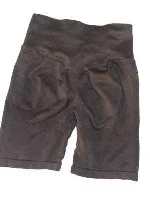 Svarta cykelshorts med hög midja - Säljer ett par svarta cykelshorts med hög midja. De är stretchiga och har en tight passform som sitter skönt på kroppen. Perfekta för träning eller när du vill ha en sportig look. Materialet känns mjukt och följsamt.