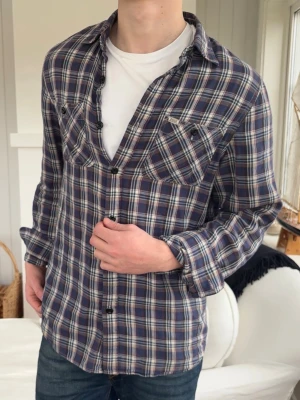 Blårutig skjorta från Ralph lauren denim supply - Snygg blårutig skjorta med långa ärmar och knappar framtill. Skjortan har två bröstfickor med lock och är tillverkad i ett mjukt bomullstyg. Perfekt för en avslappnad och stilren look.