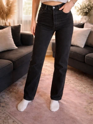 Levi’s ribcage straight - Snygga svarta Levis 501 jeans med hög midja och raka ben. Klassisk femficksmodell i jeansmaterial, perfekt för en clean och tidlös look. Passformen är normal och de har en enkel knapp- och dragkedjestängning framtill.