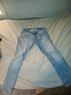 Ljusblå replay sunfade  - Säljer ett par ljusblå Levi's 511 jeans med klassisk femficksdesign och knappgylf. Jeansen har en slim passform och är tillverkade i mjuk bomullsdenim. Perfekta för dig som gillar en modern och avslappnad stil.