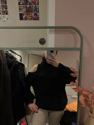 Svart stickad tröja med cut out - Trendig svart stickad tröja med polokrage och coola cut out-detaljer. 