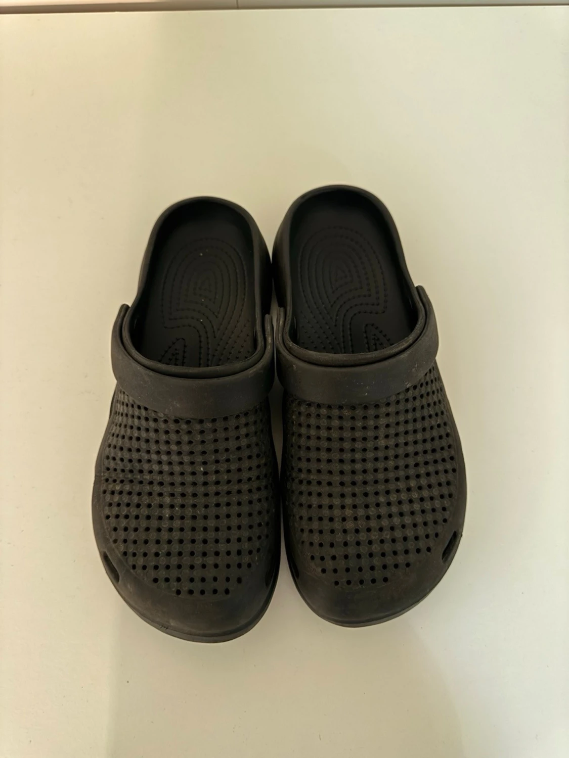 Svarta tofflor med hål