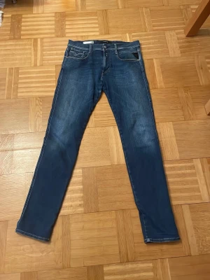 Blå raka jeans från replay Anbass  - Säljer ett par blå Replay Anbass jeans med raka ben och fem fickor. Jeansen har kontrastsömmar och en snygg tvätt. Perfekta för dig som gillar en tidlös och clean look. Hör av dig om du har frågor!  Priset kan diskuteras vid snabb affär!