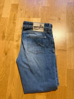 Blåa jeans från Jacob cohen  - Snygga blå jeans från jacob cohen med klassisk femficksdesign och raka ben. Jeansen har en ljus tvätt och ett diskret märke på bakfickan. Perfekta för en avslappnad och trendig look.